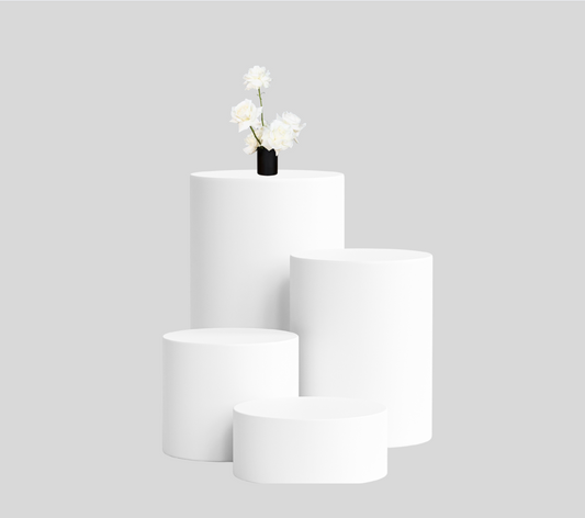 Set of four round white wood display pedestals arranged in a tiered layout on a neutral background, ideal for events or product showcases.